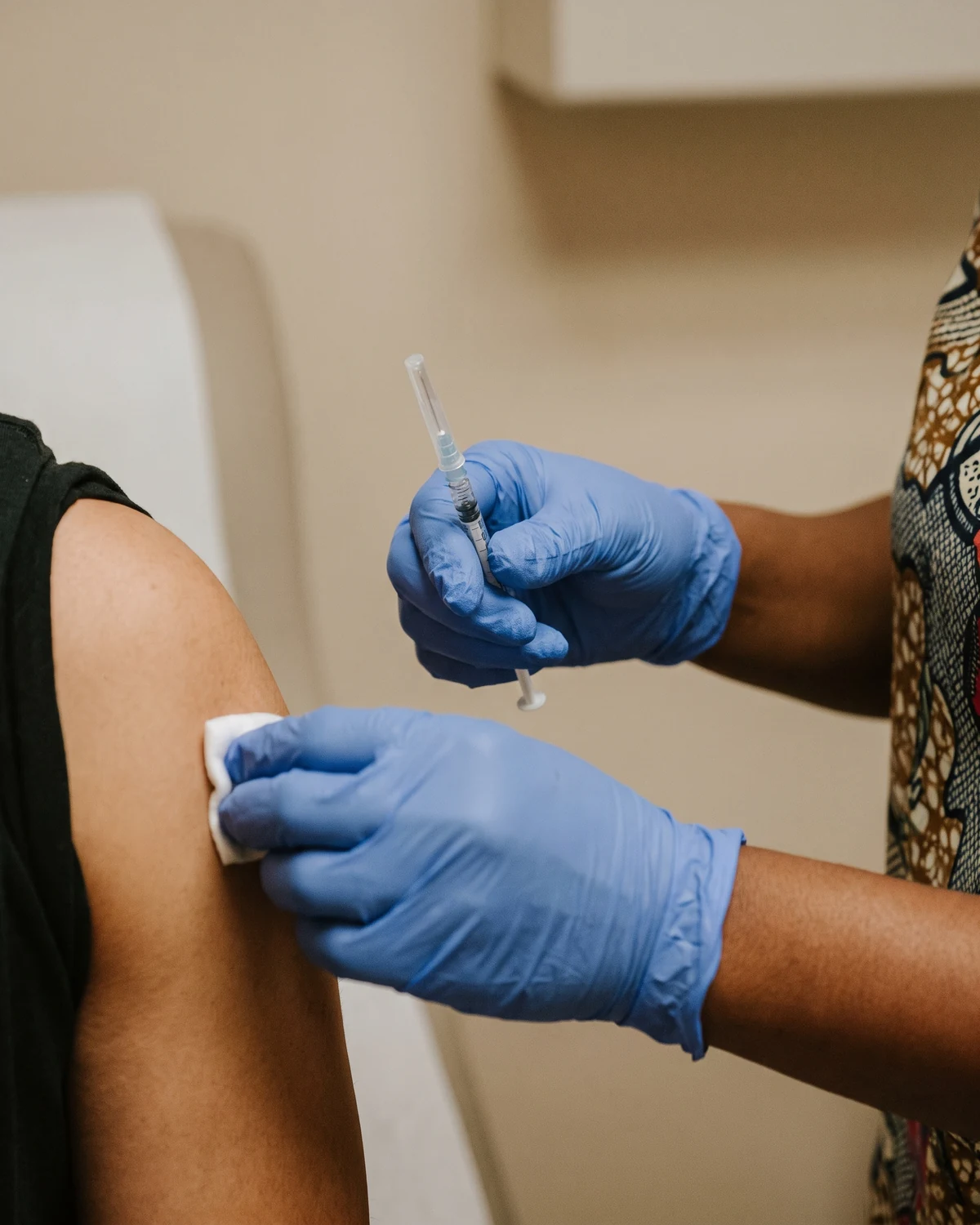 Close-up of a nurse's hands preparing a B12 injection with an alcohol swab, calm and precise.